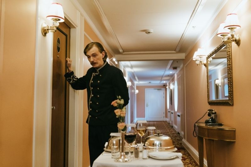 Bellhop waiting outside a hotel room